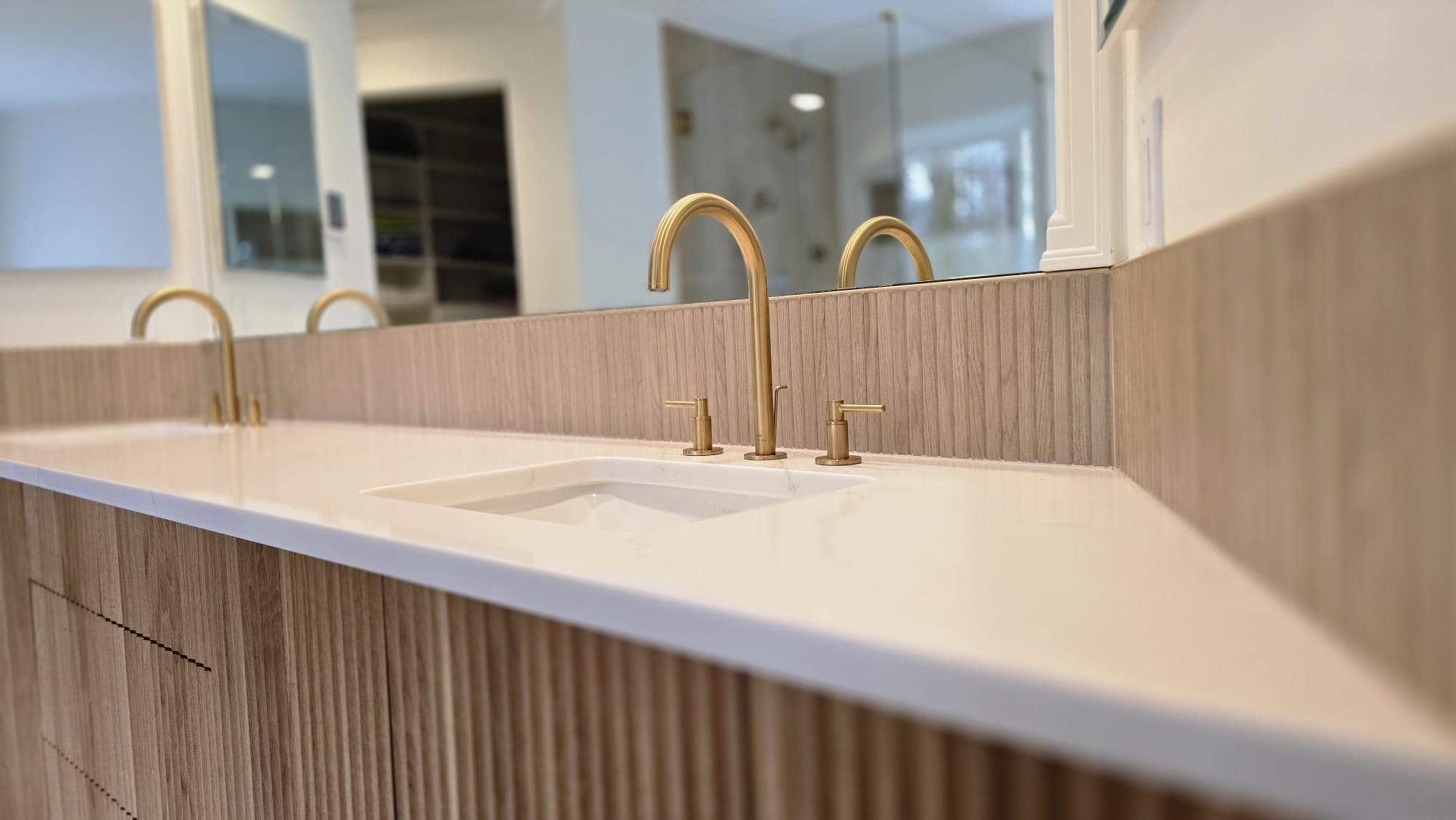 Wall-to-wall bathroom mirror above a double vanity
