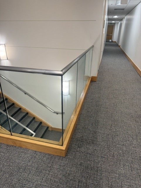 Glass stair guardrail overlooking an interior stairwell