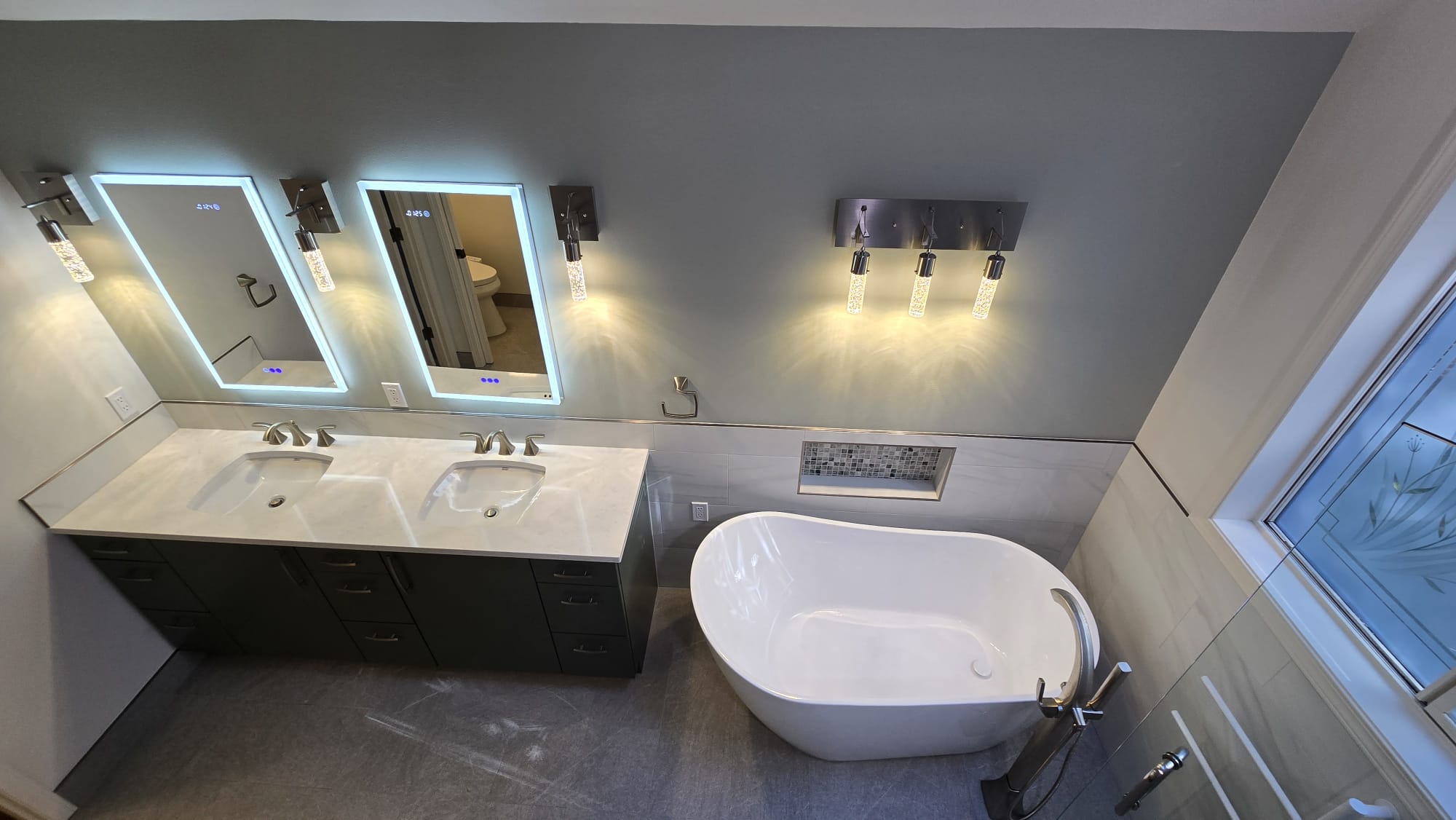Pair of illuminated mirrors in a finished bathroom