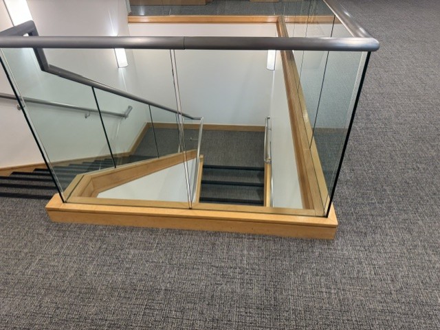 Frameless glass railing around an interior stair opening