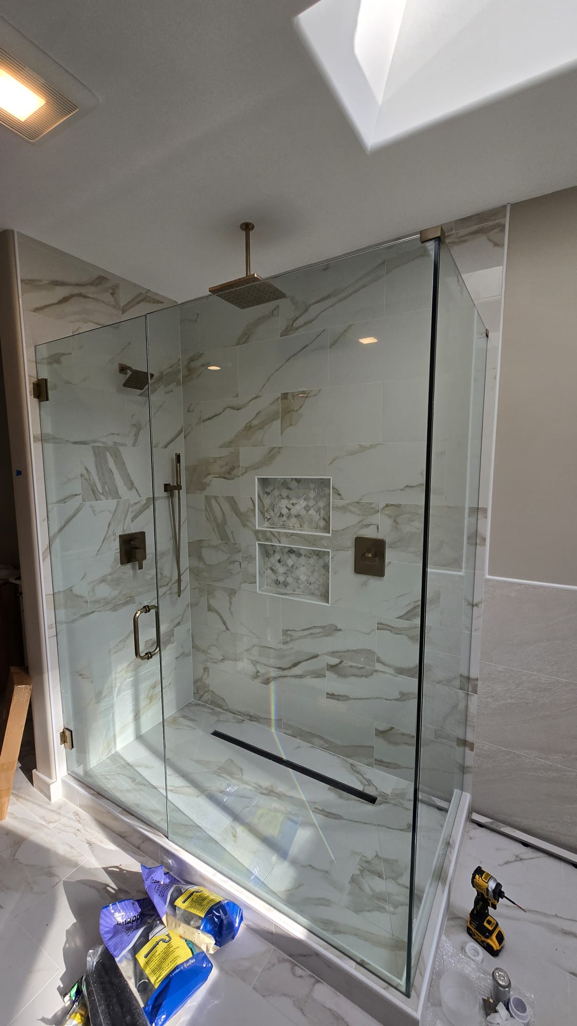 Frameless glass shower enclosure with hinged door