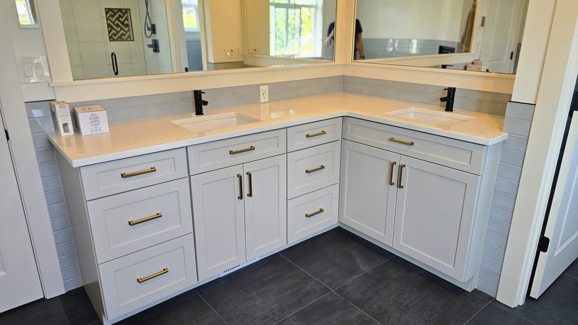 Custom corner vanity mirrors above a white cabinet