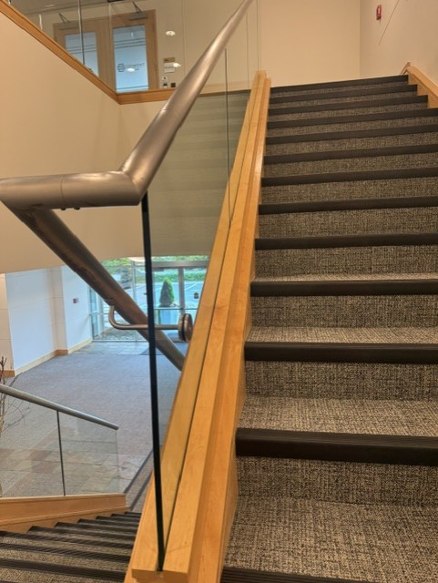 Interior glass stair railing with wood trim
