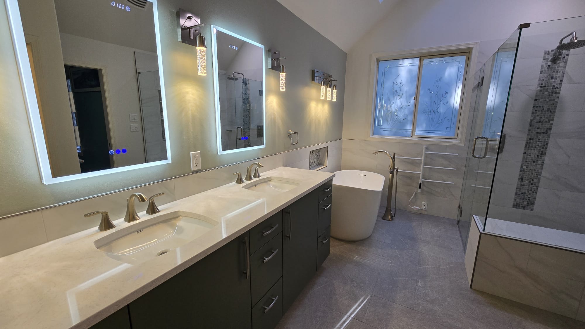 Bathroom with illuminated vanity mirrors and custom glass
